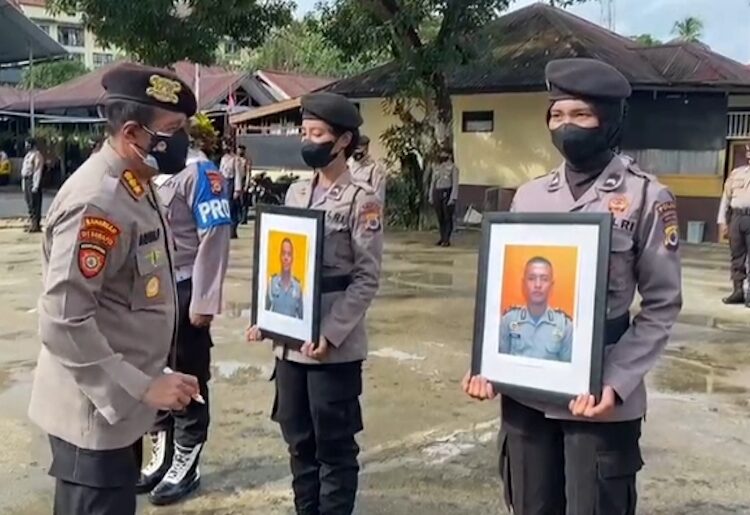 Direktur Samapta Polda Maluku Kombes Pol Agus Pujianto menulis kata PTDH pada bingkai foto empat anggota yang dipecat, Senin (30/8/2021). FOTO : Tangkapan layar