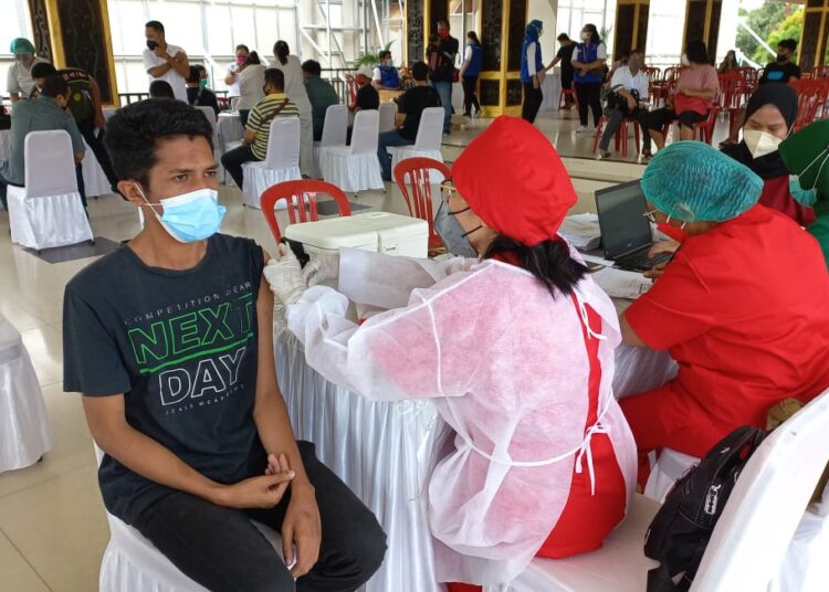 Seorang pemuda tampak disuntik vaksin covid-19 di Tribun Lapangan Merdeka, Kota Ambon, Rabu (22/9/2021). (Foto: Ambonkita.com/Husen Toisuta)