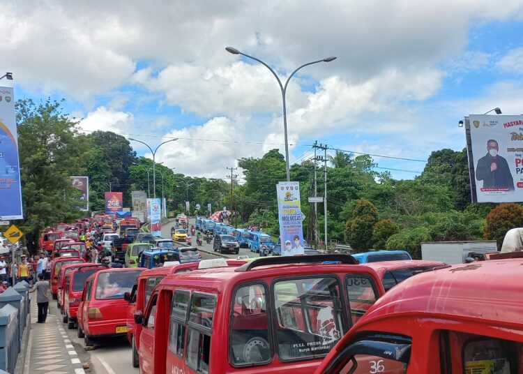 Ratusan mobil penumpang angkutan kota (Angkot) tampak terparkir sebagai bentuk aksi mogok sopir di sepanjang ruas jalan depan Underpass Sudirman, Jalan Jenderal Sudirman, Kota Ambon, Selasa (26/10/2021). (Foto: Husen Toisuta)