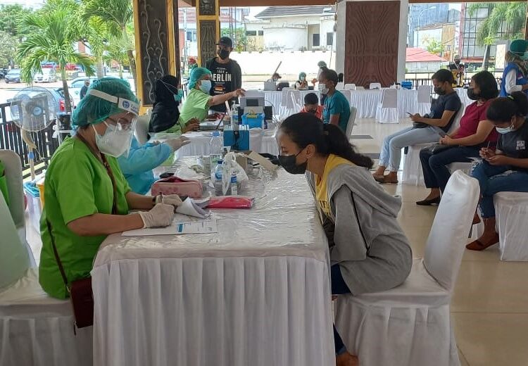 Seorang warga sedang melalui tahapan vaksin covid-19 dalam program Selebrasi Vaksinasi yang digelar Pemerintah Kota Ambon di Tribun Lapangan Merdeka, Kota Ambon, Rabu (13/10/2021). (Foto: Husen Toisuta)