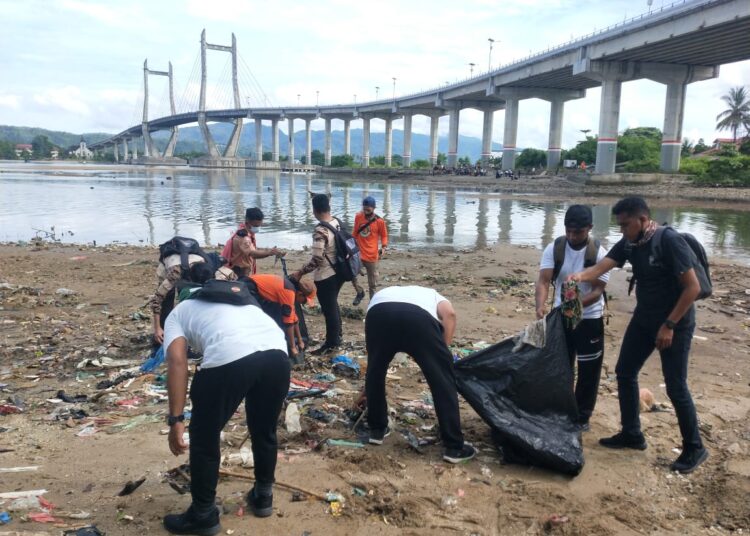 Anggota Pramuka tampak membersihkan pesisir pantai di Kota Ambon dalam kegiatan Manggurebe bersih kota dan pantai yang dilaksanakan Direktorat Binmas Polda Maluku, Rabu (17/11/2021). (Foto: Humas Polda Maluku)
