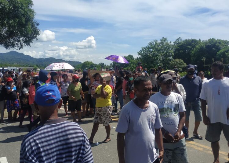 Ratusan warga Negeri Tawiri, tampak melakukan aksi palang jalan di ruas pertigaan jalan Dr. J. Leimena, Kawasan Bandara Pattimura, Kota Ambon, Rabu (24/11/2021). (Foto: Husen Toisuta)