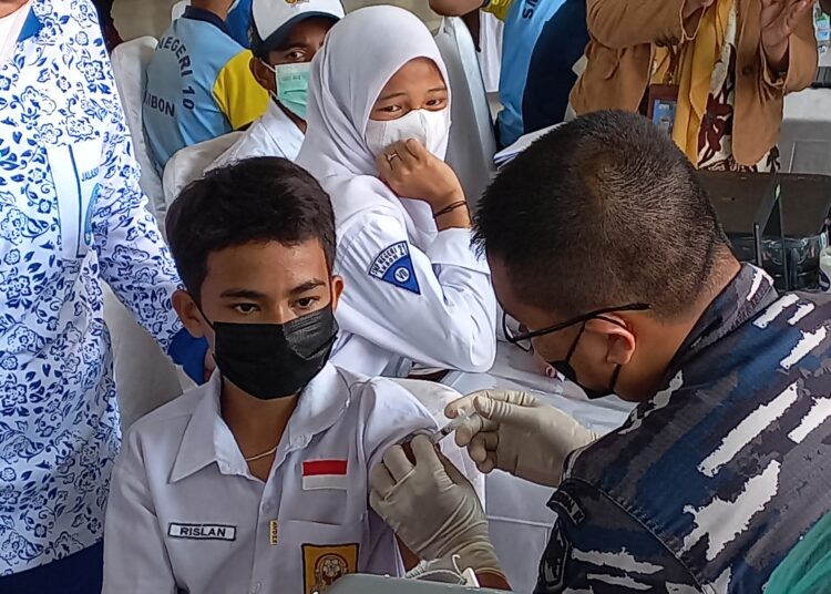 Seorang siswa SMP tampak menjalani vaksinasi covid-19 bertepatan dengan kunjungan Panglima TNI Jenderal Andika Perkasa, di Tribun Lapangan Merdeka, Kota Ambon, Kamis (9/12/2021). (Foto: Husen Toisuta)