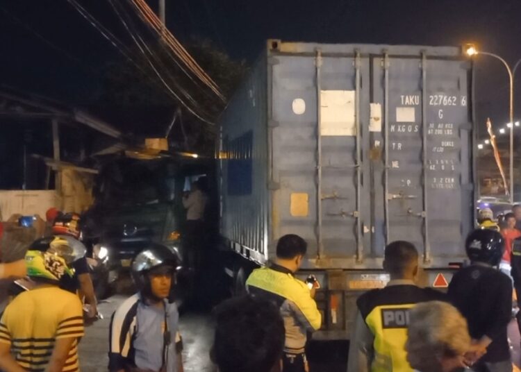Truk kontener tampak nyungsep ke rumah warga di Jalan Jenderal Sudirman, Kota Ambon, Rabu (1/12/2021). (Foto: Husen Toisuta)