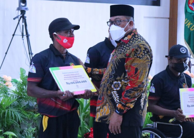 Gubernur Maluku Murad Ismail menyerahkan bonus kepada perwakilan atlet berprestasi pada PON dan PEPARNAS Papua, di Lantai 7 Kantor Gubernur Maluku, Kota Ambon, Jumat (3/12/2021). (Foto: Humas Pemprov)