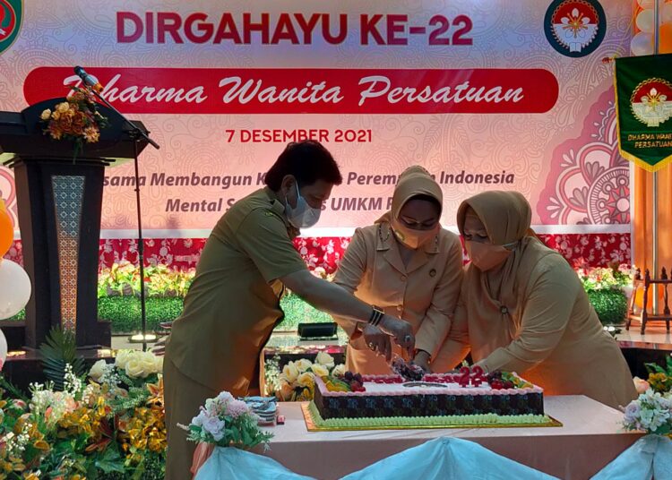 Sekda Maluku Sadali Ie (kiri) tampak memotong Kue HUT ke 22 Dharma Wanita Persatuan Provinsi Maluku di Gedung PKK Maluku, Kota Ambon, Selasa (7/12/2021). (Foto: Humas Pemprov Maluku)