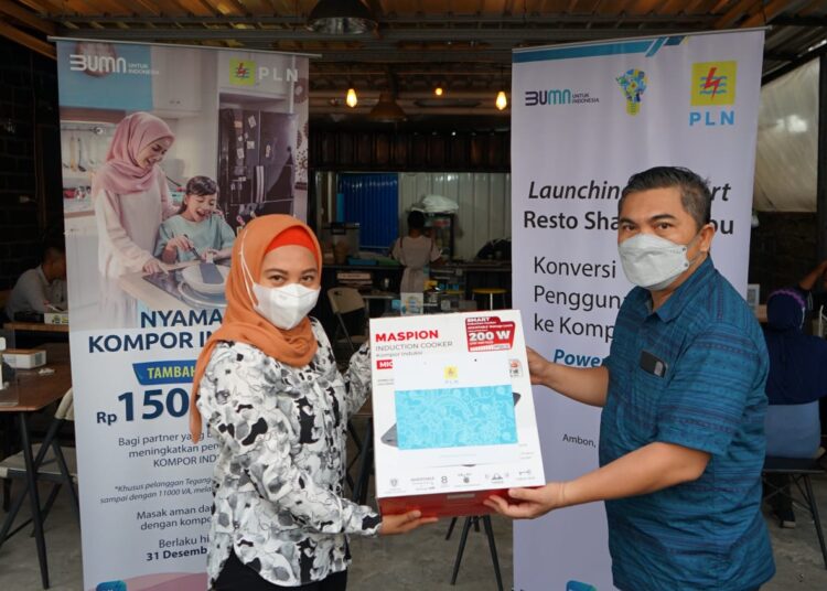 Manager PLN UP3 Ambon, Yusrizal (kanan) tampak menyerahkan bantuan kompor induksi ke salah satu pelaku usaha, Arfina Abbas, pemilik The Pension Cafe di Ambon, Sabtu (18/12/2021). (Foto: Humas PLN Maluku)