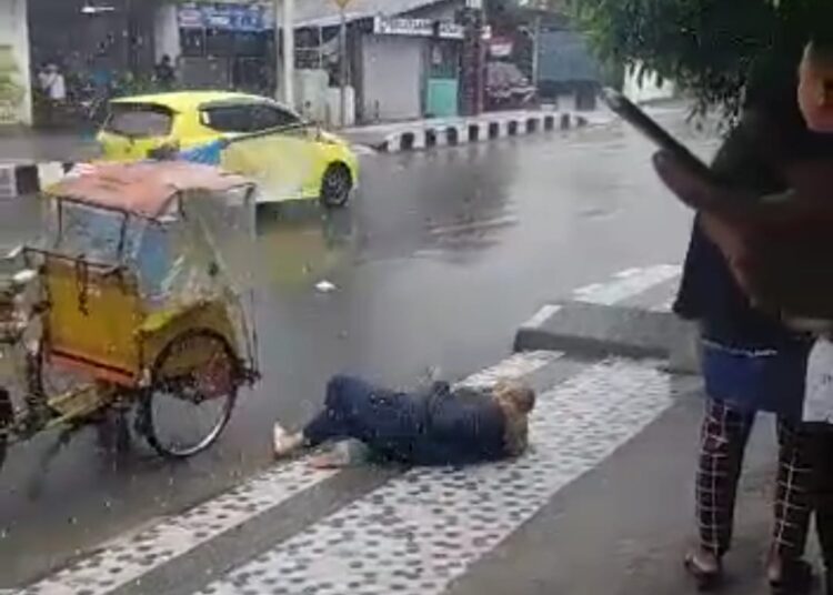 Seorang ibu tampak terjatuh akibat trotoar licin di Kawasan Jalan Baru, Kecamatan Nusaniwe, Kota Ambon, Senin (27/12/2021). (Foto: Tangkapan Layar)