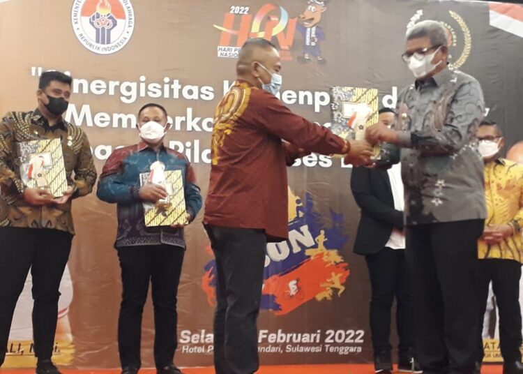 Bupati Maluku Tenggara M. Thaher Hanubun tampak menerima penghargaan Inisiator Olahraga dari Ketua PWI Pusat, Atal S Depari, di Kendari, Sulawesi Tenggara, Selasa (8/2/2022). (Foto: Istimewa)