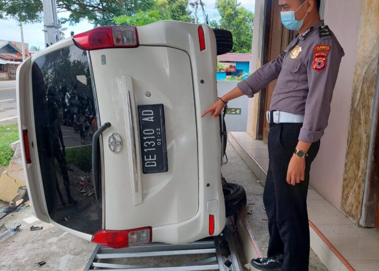 Sebuah mobil tampak terbalik di depan pertokoan Jalan dr. J. Leimena, Kecamatan Teluk Ambon, Kota Ambon, Rabu (23/2/2022). Mobil itu terbalik setelah menabrak sebuah pengendara sepeda motor hingga meninggal dunia di TKP. (Foto: Humas Polresta Ambon)