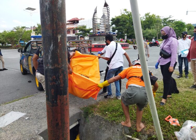 Polisi tampak mengevakuasi sesosok mayat perempuan tanpa identitas yang ditemukan dalam gorong-gorong bundaran Kota Masohi, Kabupaten Maluku Tengah, Rabu (9/3/2022). (Foto: Istimewa)