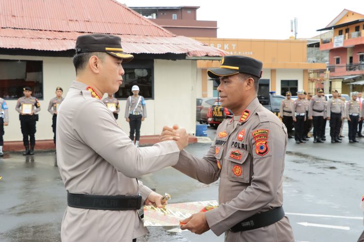 Kapolresta Pulau Ambon dan Pulau-pulau Lease, Kombes Pol Driyano Andri Ibrahim (kiri) saat menyerahkan piagam penghargaan kepada Kapolsek KPYS Ambon AKP. Julkisno Kaisupy saat upacara pemberian reward personel berprestasi di Markas Polresta Ambon, Parigilima, Kota Ambon, Senin (6/5/2024). (Foto: Istimewa)