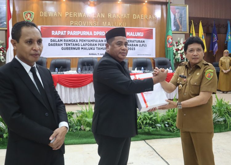 Penjabat Gubernur Maluku Sadali Ie menyerahkan LPJ Gubernur Maluku Tahun 2023 kepada Ketua DPRD Maluku Benhur G Watubun dalam rapat paripurna DPRD, Selasa (11/6/2024). FOTO : DISKOMINFO Maluku