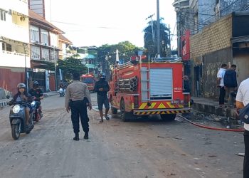 Satu unit pemadam kebakaran tampak melakukan pendinginan pada satu unit ruko yang terbakar akibat bentrokan antar pemuda yang terjadi di kawasan Tugu Trikora, Kota Ambon, Minggu dini hari (12/1/2025). (Foto: Husen Toisuta/Ambonkita.com)